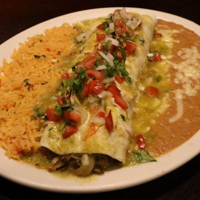 Enchilada, topped with salsa, with rice, and refried beans on the side.