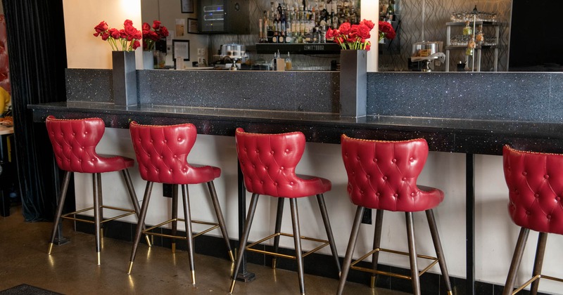 Interior, bar with chairs, drink rack behind