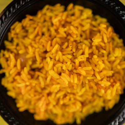 Yellow Rice served in a black plate, close-up.