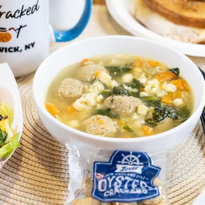 Bowl of Italian Wedding Soup with meatballs and pasta.