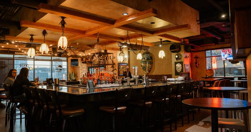 Interior, bar area, ''U'' shaped bar with bar stools, concrete flooring, drink shelf