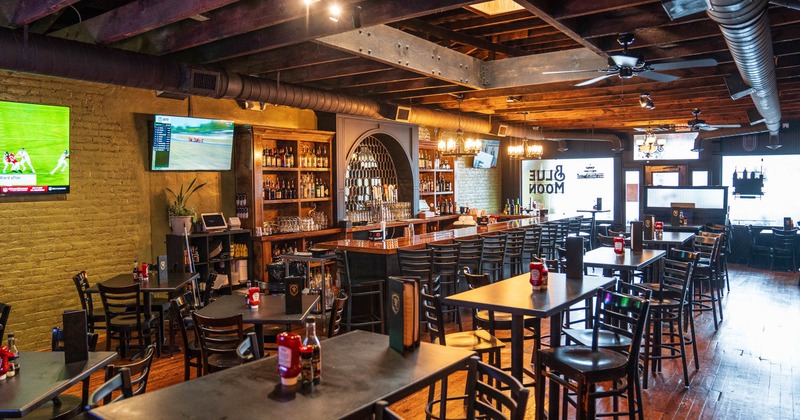 Pub interior, bar with stools, high seating tables with chairs, regular tables for four