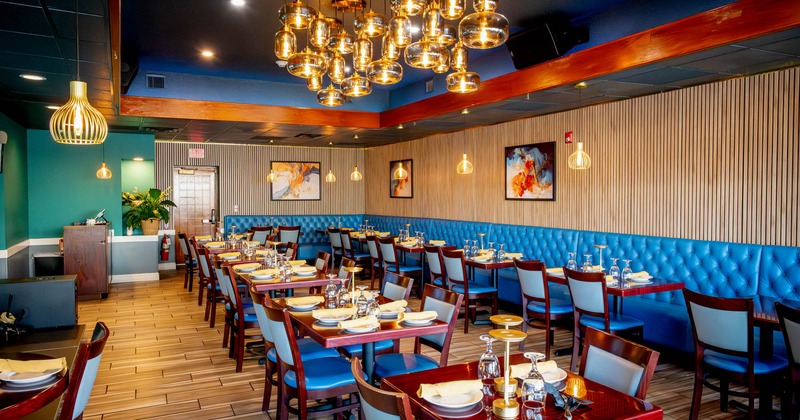 Interior, dining area, tables for four and two, long banquette bench with tables and chairs