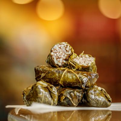 Stack of stuffed grape leaves, with one cut in half.