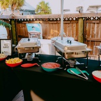Outdoors, buffet table with chafing dishes and food bowls.