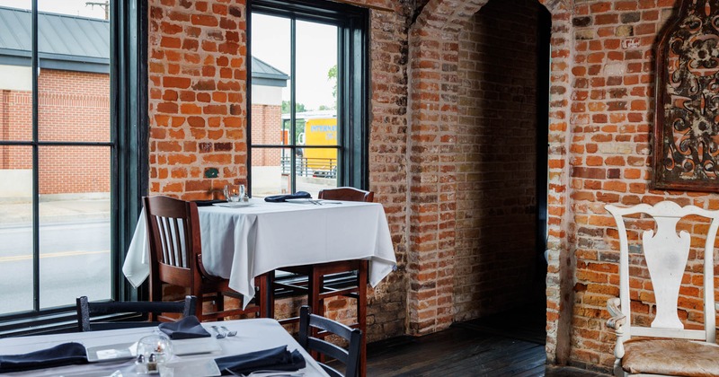 A table with bar stools next to the large window