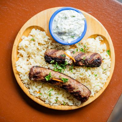 Grilled sausages, rice, and tzatziki.