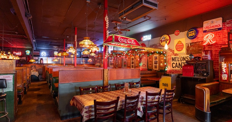 Spacious dining area with wooden tables and chairs, comfortable booths, and retro decorations