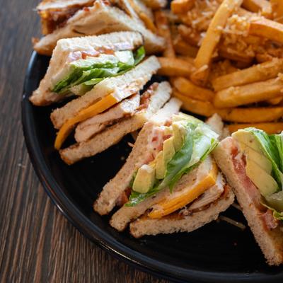 Club sandwich served with fries, close-up.
