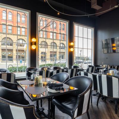 Interior, black and white striped chairs, dark leather seating, and dark walls.