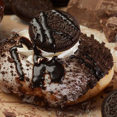 Oreo donut with whipped cream, Oreo cookie, and chocolate drizzle topping.