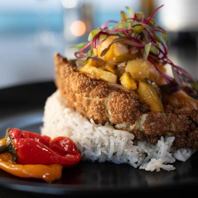 Crispy cauliflower steak, on a bed of rice, with citrus slaw.