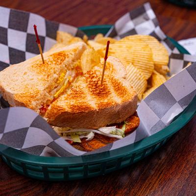 A toasted sandwich with a side of potato chips.
