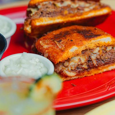 Torta sandwich with sliced beef filling served with chopped onions.