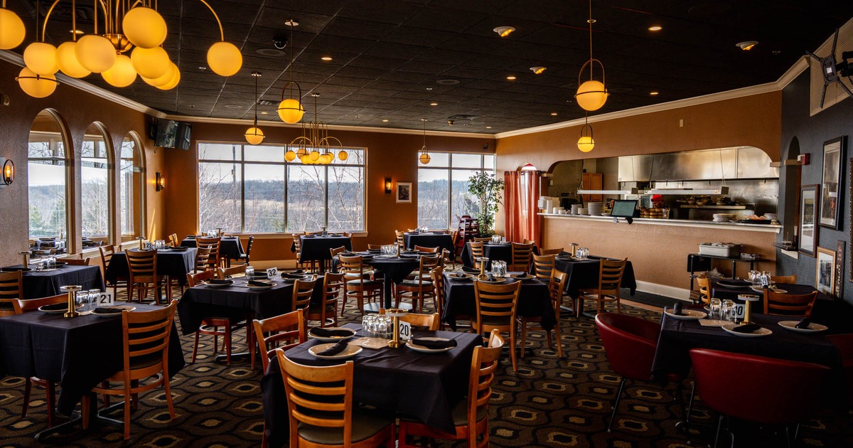 Interior, open space dining area, tables with chairs ready for guests, carpet flooring
