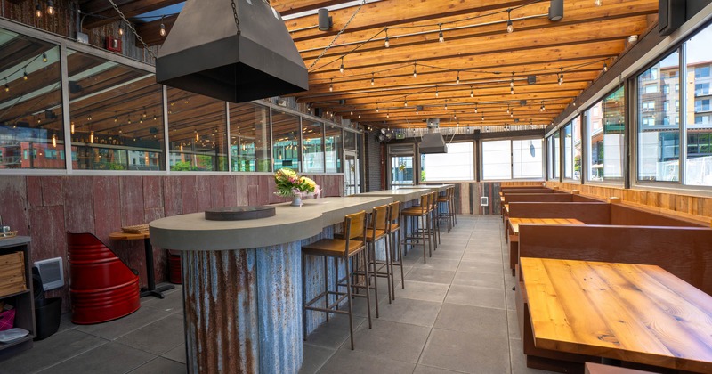 Patio, outdoor grill, seating booths with tables, high seating tables with stools, lanterns