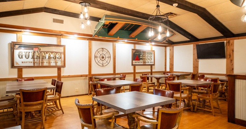 Interior, seating area with tables and chairs, boat hanging from a ceiling