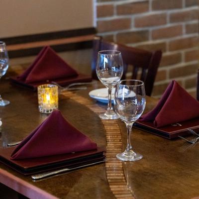 Table set with folded napkins, wine glasses, side plates and cutlery.