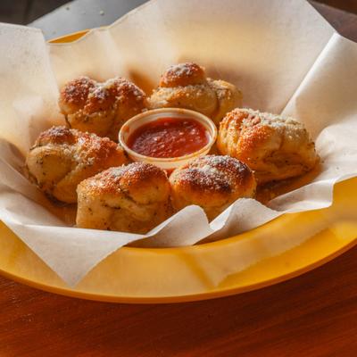 Portion of garlic knots with dip.