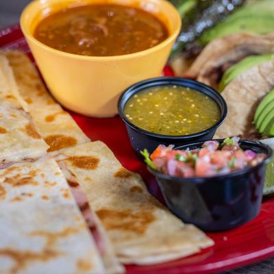 Quesadillas with tacos and salsas on a plate.