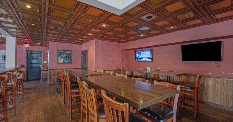 Interior, long dining tables, chairs, TVs on the wall