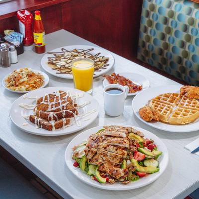 A table with assorted dishes, coffee, and orange juice on it.