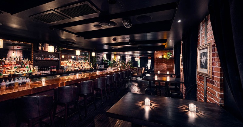 Interior, seating area, wooden top bar with stools, high seating tables for four, brick walls