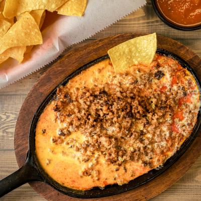 Chori Queso served in a skillet with side of nachos.