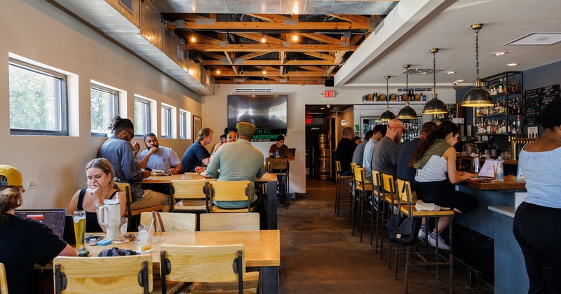 Interior space full of guests, seating area and bar