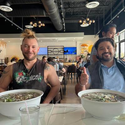 Two guests with large bowls of soup.