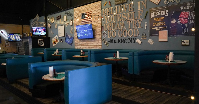Interior with blue booths, round tables and vintage wall décor