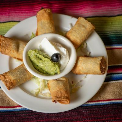 Flautas, served with sour cream and guacamole.