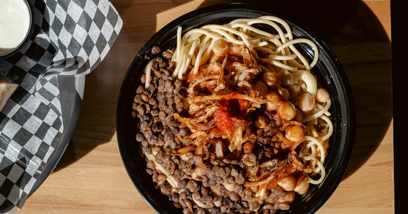 Koshari Bowl on a sun lit table, overhead view
