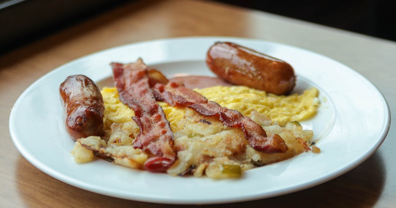 Scrambled eggs with ham,  sausage, and bacon