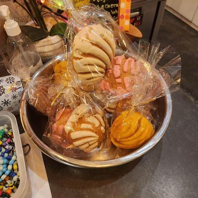 Bowl of Mexican sweet bread pastries wrapped in transparent foil.