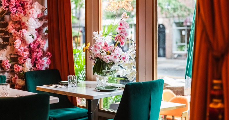 Dining table set for two guests by the window, flower decoration
