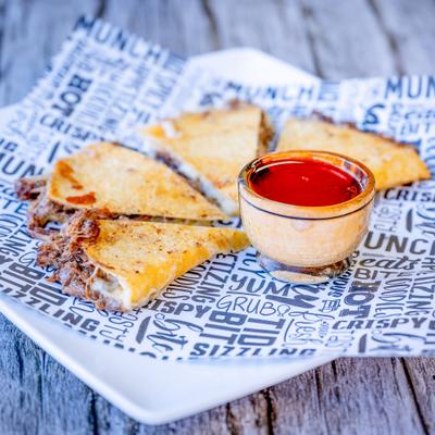 Quesabirria served with a dip.