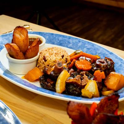 Oxtail with vegetables, rice, and plantains