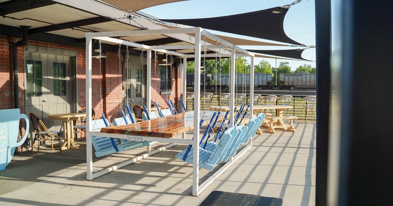 Exterior, seating area, table for eight with swinging chairs, regular tables for two