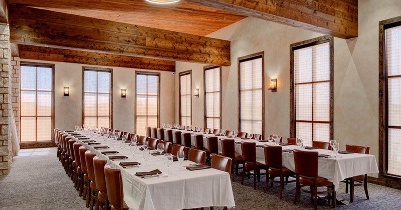 Interior, two long set tables ready for guests