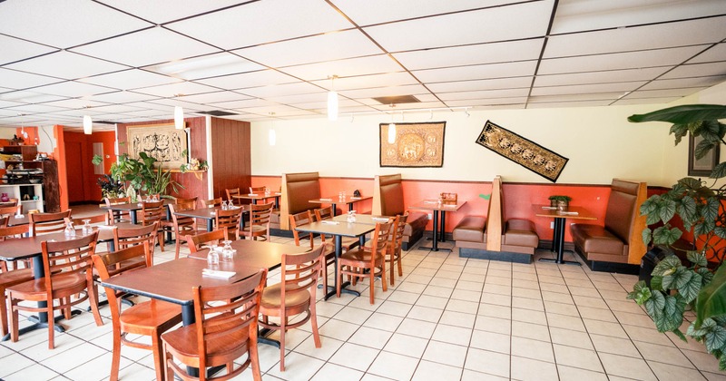 Restaurant interior with wooden tables and chairs, booth seating along the wall