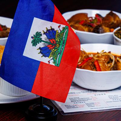 Haitian flag beside assorted dishes on the table.