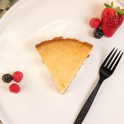 Cheesecake slice on plate garnished with berries.