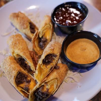 Philly cheese steak egg rolls served with spicy Chinese mustard, and sweet chili sauce.