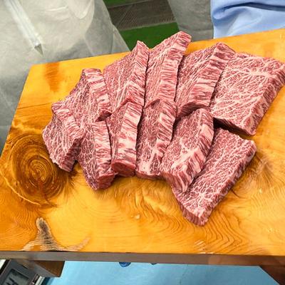 Slices of marbled beef arranged on a textured wooden board.