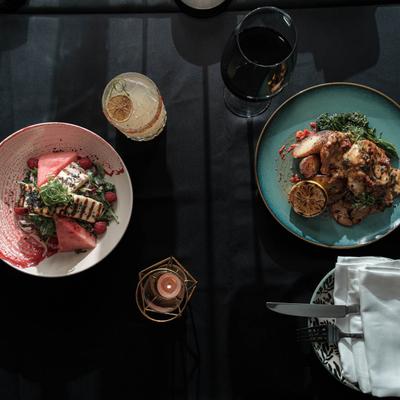 Pan seared salmon and Chicken Anabella dish, served with wine  and a cocktail, top view.