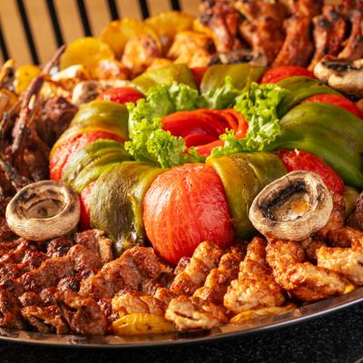 Family platter with mixed meats, potatoes, veggies, and mushrooms.