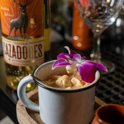 Cocktail served in a mug served with bottle of tequila.