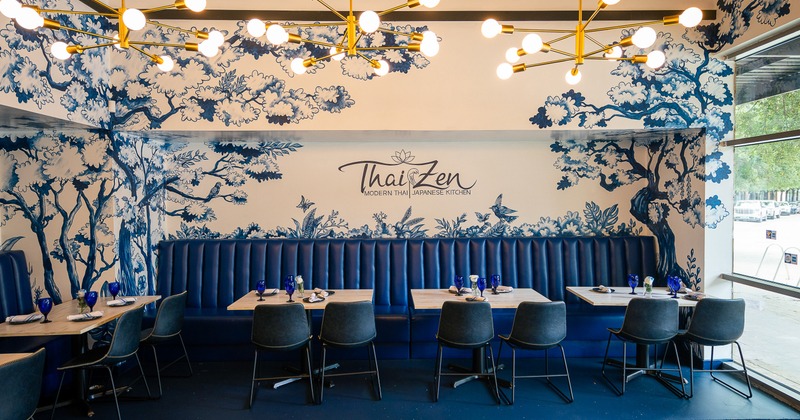 A stylish and modern restaurant interior with elegant blue and white mural artwork