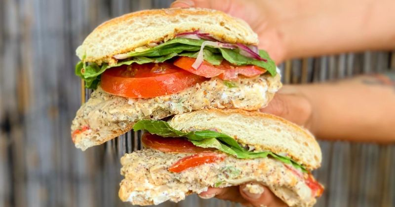Hands holding sandwiches, closeup, background blur